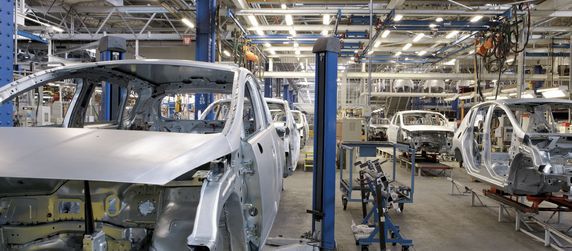 Eine Automobilfertigungslinie mit mehreren Auto-Rahmen, die verschiedenen Prozessphasen zeigen.