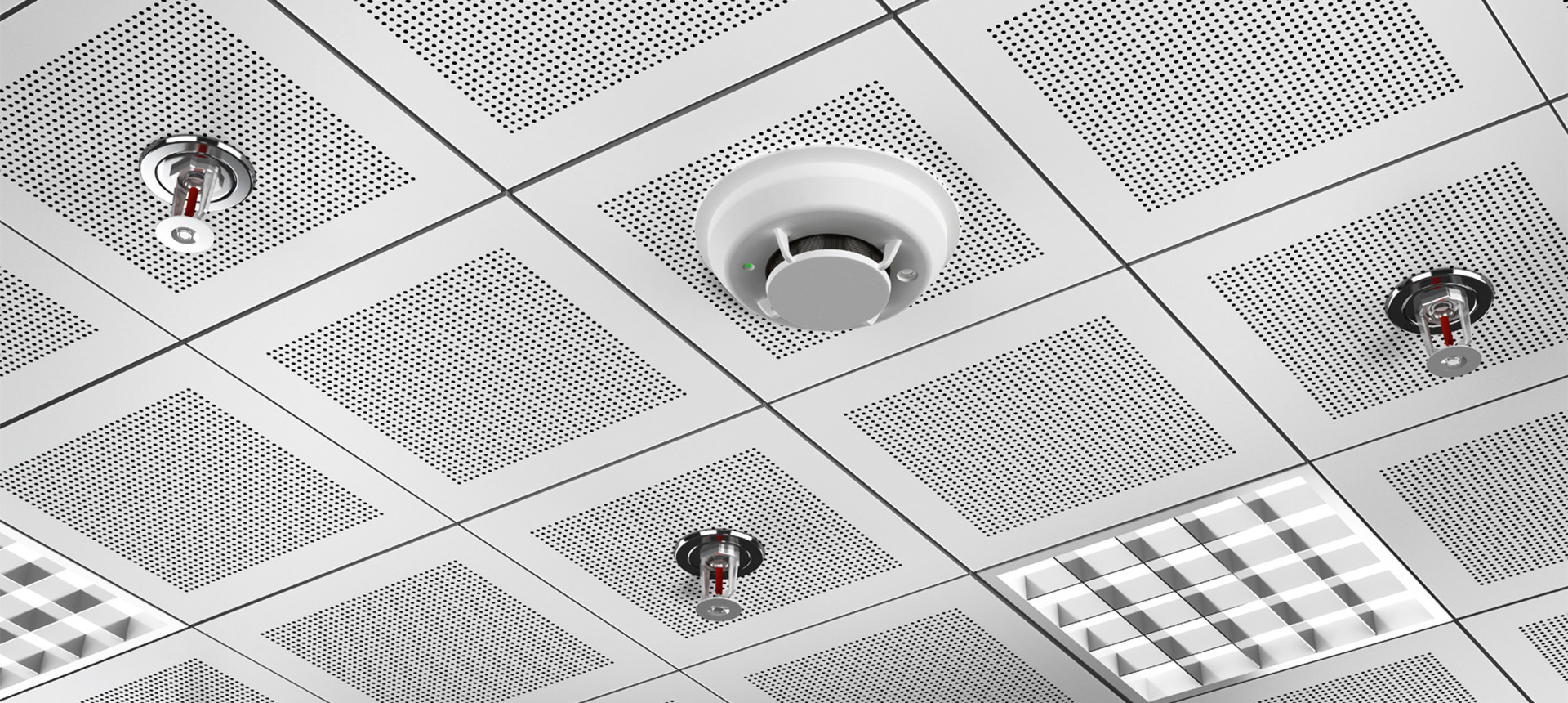 Eine Decke mit mehreren Brandschutzvorrichtungen, darunter ein Rauchmelder und Sprinklerköpfe.